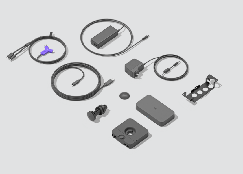 Hub Laptop Logitech para Video Conferencia 2xHDMI 1xUSB 2xUSB-C NEGRO (952-000009) 1 assortment of computer accessories and cables laid out on a light gray background, including USB and power cables, adapters, and a docking hub.