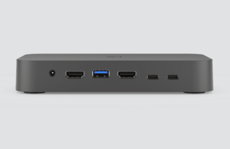 Hub Laptop Logitech para Video Conferencia 2xHDMI 1xUSB 2xUSB-C NEGRO (952-000009) 2 Front view of a dark gray mini PC/docking hub with power jack, HDMI, blue USB 3.0 A port, HDMI, and two USB-C ports.