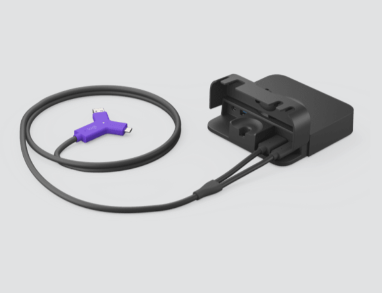 Hub Laptop Logitech para Video Conferencia 2xHDMI 1xUSB 2xUSB-C NEGRO (952-000009) 3 Black charging dock connected to a cable with a purple USB connector at the end, resting on a light background.